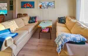 a living room with a couch and a table at 3 Bedroom Cozy Home In Skjærhalden in Skjærhollen