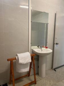 un bagno bianco con lavandino e doccia di Manureva Lodge a Faaa