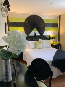 a bedroom with a large bed and a vase with a flower at Hotel Boutique Valle de Oca in Villanasur-Río de Oca