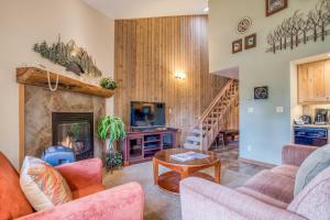 Una sala de estar con chimenea y una escalera. en Ski House 245 - Meredith Lodging, en Bend