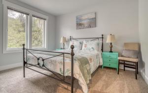 a bedroom with a bed and a chair and windows at Jims Folly in Depoe Bay