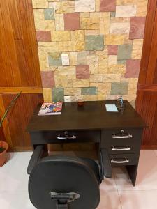 Una oficina con un escritorio con una silla y una pared de piedra. en MonoAmbiente Cómodo Como en Casa, en Tarija