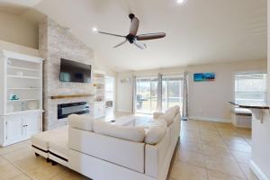 ein Wohnzimmer mit einem weißen Sofa und einem Deckenventilator in der Unterkunft Simply Serene in Rotunda-West