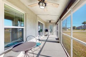 eine Veranda mit einem Tisch, Stühlen und einem Fenster in der Unterkunft Simply Serene in Rotunda-West