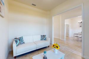 ein Wohnzimmer mit einer weißen Couch und einem Tisch in der Unterkunft Simply Serene in Rotunda-West