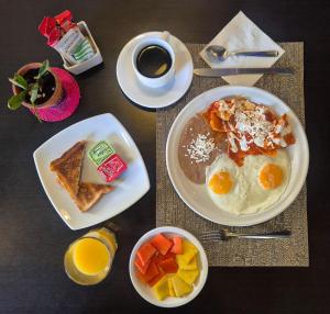 a table with plates of breakfast food and a cup of coffee at Pórtico Hotel & Galería in Morelia