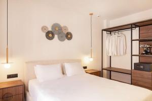 a bedroom with a bed and a clock on the wall at Aeolis Hotel in Samos