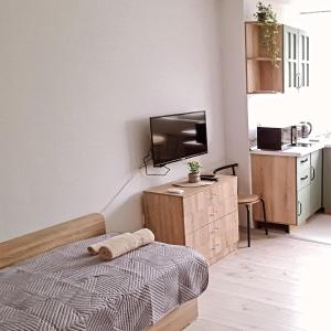 ein Schlafzimmer mit einem Bett und einem Fernseher an der Wand in der Unterkunft Апартаменти за Гости ИвАя Запад Казанлък in Kasanlak
