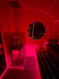 um quarto com luzes cor-de-rosa e uma janela em Maringotka u lesa em Staňkovice