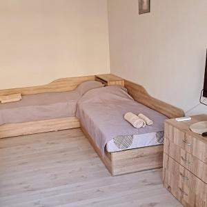 ein Schlafzimmer mit einem Holzbett und einer Kommode in der Unterkunft Апартаменти за Гости ИвАя Запад Казанлък in Kasanlak