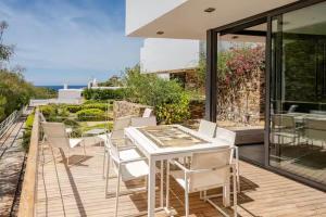 una mesa blanca y sillas en una terraza de madera en Exclusiva casa con encanto en Agua Amarga, en Agua Amarga