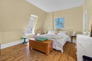 a bedroom with a white bed and a wooden floor at Hamilton Hilltop Home3 King Bedsvictoria Park in St. John's