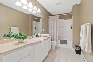 een witte badkamer met een wastafel en een toilet bij Forest House Qv Lake View Parking in St. John's +28 foto's