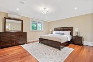 een slaapkamer met een bed, een ladekast en een spiegel bij Forest House Qv Lake View Parking in St. John's