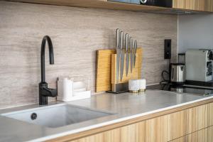 encimera de cocina con fregadero y perchero para cuchillos en Villa Perla Mare - Sauna Experience - On a lake near Amsterdam, en Vinkeveen