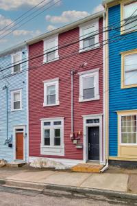a red building with white windows on a street at Historic Jelly Bean Row House, Walk To Signal Hill in St. John's