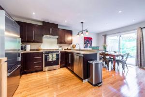 a kitchen with wooden floors and a dining room with a table at Harbour View Hitch 2BR w Parking & Deck in St. John's