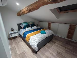a bedroom with a bed and a wooden floor at L'Escale in Grisolles