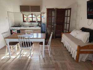 a kitchen and dining room with a table and a bed at Las Carolas in Santa María