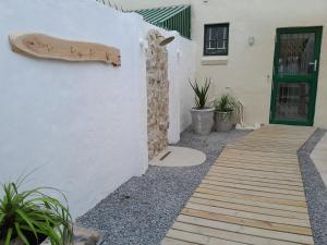 a house with a wooden walkway next to a door at Ohana House - Unbeatable Location - Sea Views in Port Alfred