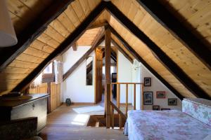 a attic room with a bed and a wooden ceiling at Oazena , Authentic house in peaceful village in Selnica