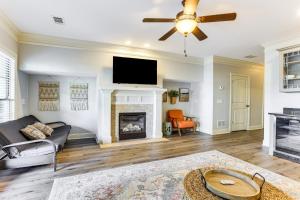 a living room with a fireplace and a ceiling fan at Private Patio, Decks Waterfront Eatonton Townhome in Eatonton 