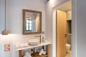 a bathroom with a sink and a mirror at Nisomar Suites in Symi +60 photos