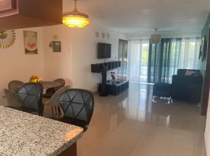 a kitchen and living room with a table and chairs at Santuario Tropical at Marino Paradise in La Puntica de Juan Dolio