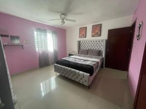 a bedroom with pink and purple walls and a bed at Santuario Tropical at Marino Paradise in La Puntica de Juan Dolio