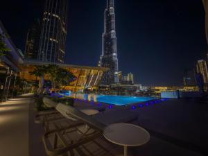NYE Burj Khalifa & Fountain View Balcony Escape في دبي: مسبح على السطح مطل على المدينة ليلا