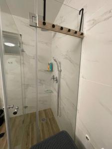 a bathroom with a shower with a glass door at kasa or in Herzelia  +13 photos
