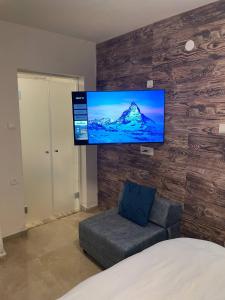 a room with a couch and a tv on a wall at kasa or in Herzelia 