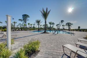 Highland ViewにあるSteps to Shore Windmark Beach Retreat with Balcony!のベンチとヤシの木があるスイミングプール