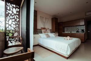 a bedroom with a large white bed and a chair at SOLEMN Cabañas Villaseñor in Tulum +21 photos