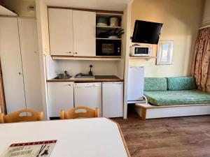 a small kitchen with a couch and a refrigerator at Résidence Le Sextant - SEXTANT 405 MAE-0551 in La Plagne Tarentaise