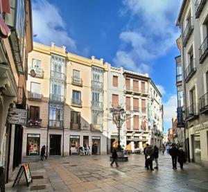 a city street with buildings and people walking around at San José y Maderuelo A in Ávila