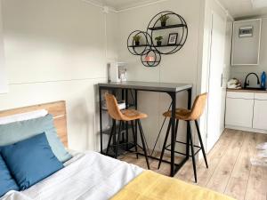 una camera da letto con un tavolo, due sedie e un letto di Tiny House with Mountain Views a Turany