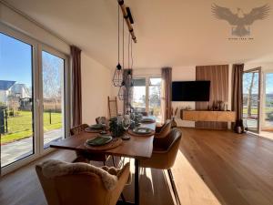 a dining room with a table and chairs and a television at River Lake Inn - Muldestausee in Pouch