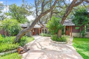 una casa con un árbol delante en Lawlis Lodge, en Wimberley