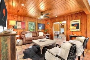 una sala de estar con muebles y paredes de madera. en Lawlis Lodge, en Wimberley
