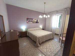 a bedroom with a bed and two tables and two windows at La Casetta della fontana del muro in San Lorenzo Nuovo