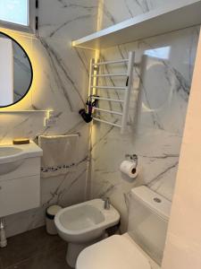 a white bathroom with a toilet and a sink at Al Mare in Monte Hermoso +22 photos