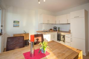 ヴィーク・アウフ・リューゲンにあるFerienwohnung Wiek im Hafenkiekerのキッチン(木製テーブル、キャンドル付)