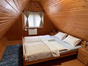 una camera da letto con un letto in una stanza di legno di Chata Jánošík a Terchová
