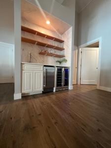 ein leeres Wohnzimmer mit einer Küche und Holzböden in der Unterkunft Bonfire at Batali in Salisbury