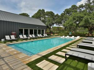 a swimming pool with lounge chairs and a building at Luxurious New Unit 1Bd1BaPool, Golf Sim in Austin