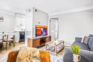 a living room with a couch and a tv at Embrace Austins Vibrant Heart Elegant 1BR Haven in Austin