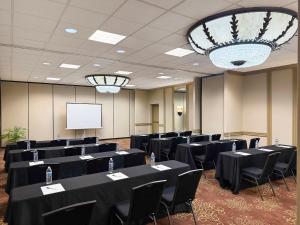 a conference room with black tables and chairs and a screen at Holiday Inn South Plainfield-Piscataway by IHG in South Plainfield +26 photos