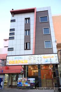 a tall building with a sign in front of it at Hotel Deepam in Tiruchchirāppalli