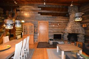 a living room with a fireplace in a log cabin at Northern Lights in Levi